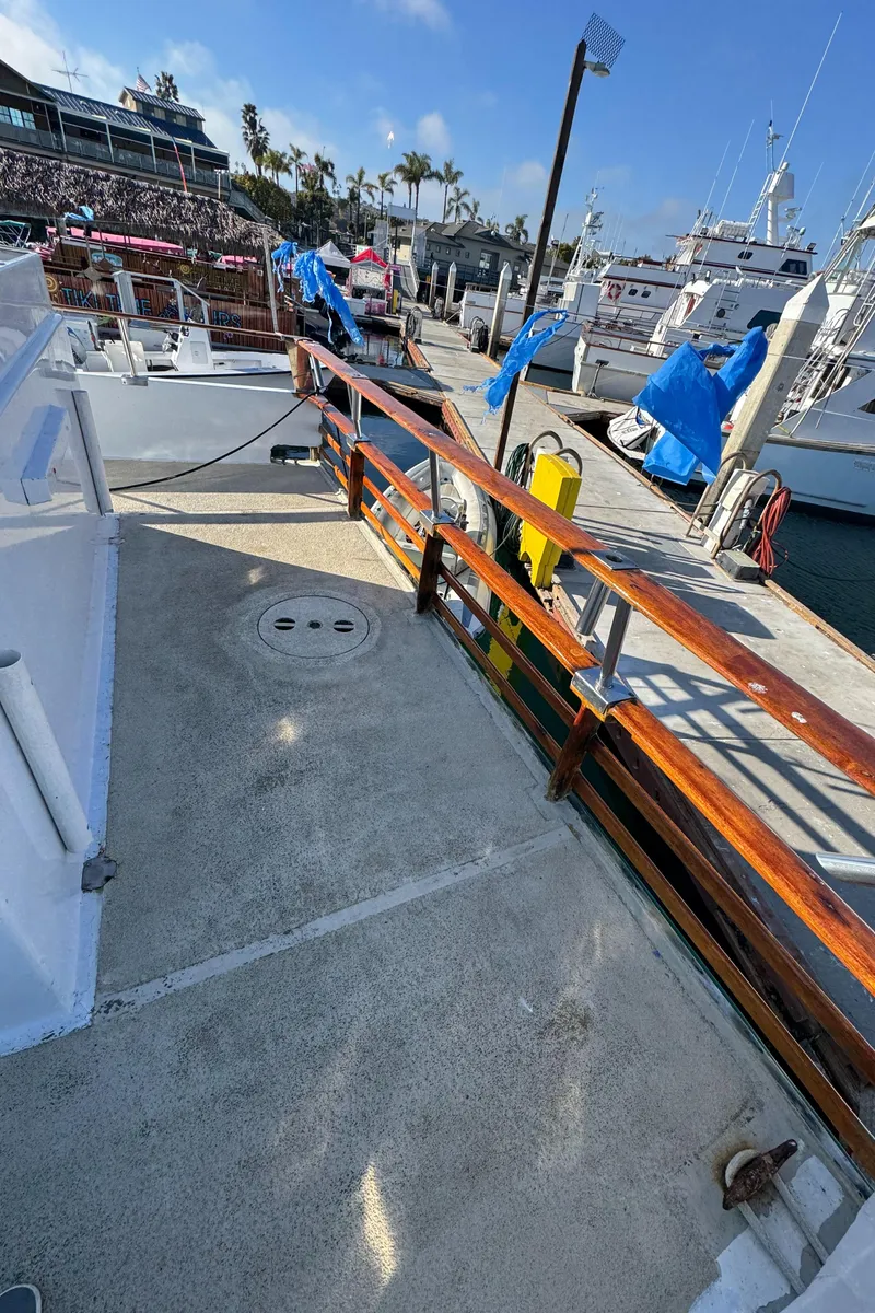 Slide: The Image of 1966 Seaway Commercial Sportfish Vessel docked at marina, featuring wooden railings and clear skies. - 16
