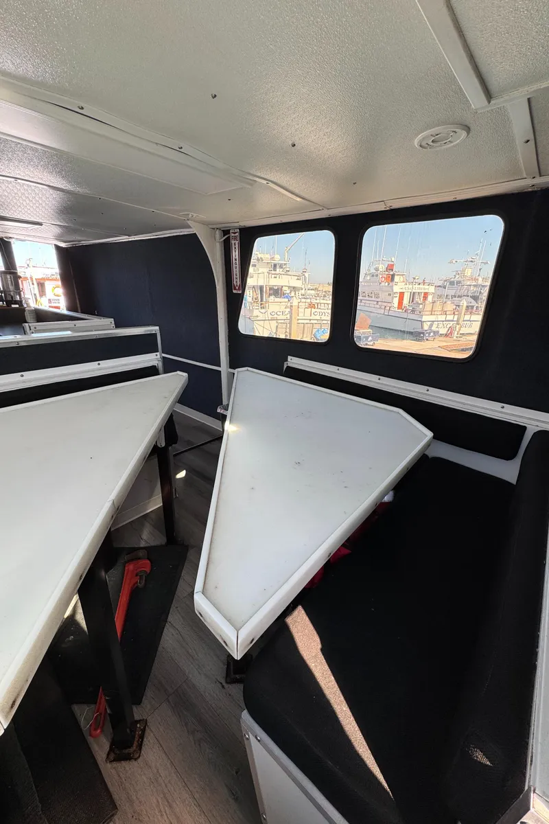 Slide: The Image of Interior of a 1966 Seaway Commercial Sportfish Vessel, featuring triangular tables and seating. - 32
