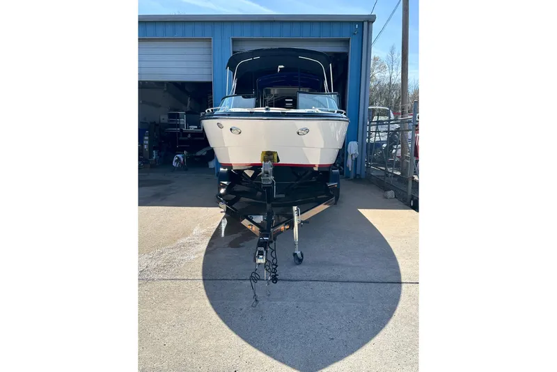 Slide: The Image of 2016 Monterey 238SS Super Sport boat on trailer outside a blue garage. - 2