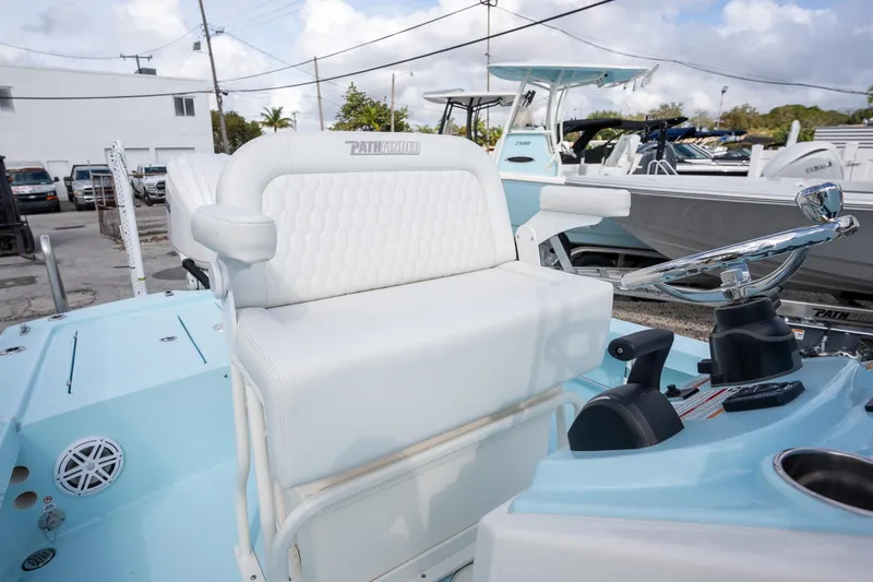 Slide: The Image of 2025 Pathfinder 2300 HPS boat interior with white seating and steering wheel. - 10