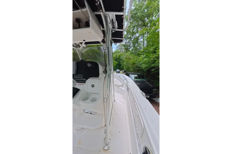 Slide: The Image of 2005 Wellcraft 232 Fisherman boat interior with console and seating, surrounded by trees. - 10