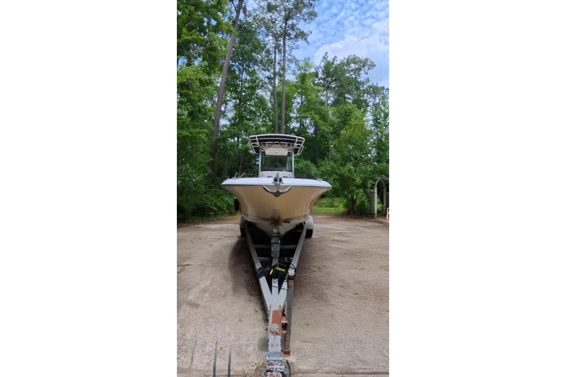 Slide: The Image of 2005 Wellcraft 232 Fisherman boat on trailer, surrounded by lush greenery. - 2