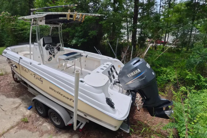 Slide: The Image of 2005 Wellcraft 232 Fisherman boat with Yamaha motor on trailer in wooded area. - 3