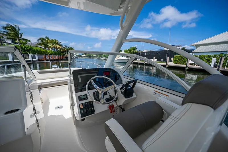 Slide: The Image of Cockpit view of 2020 WorldCat 255 DC boat, featuring steering wheel and controls, dockside. - 16