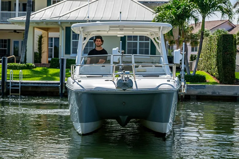 Slide: The Image of Front view of a 2020 WorldCat 255 DC boat docked near a waterfront home. - 2
