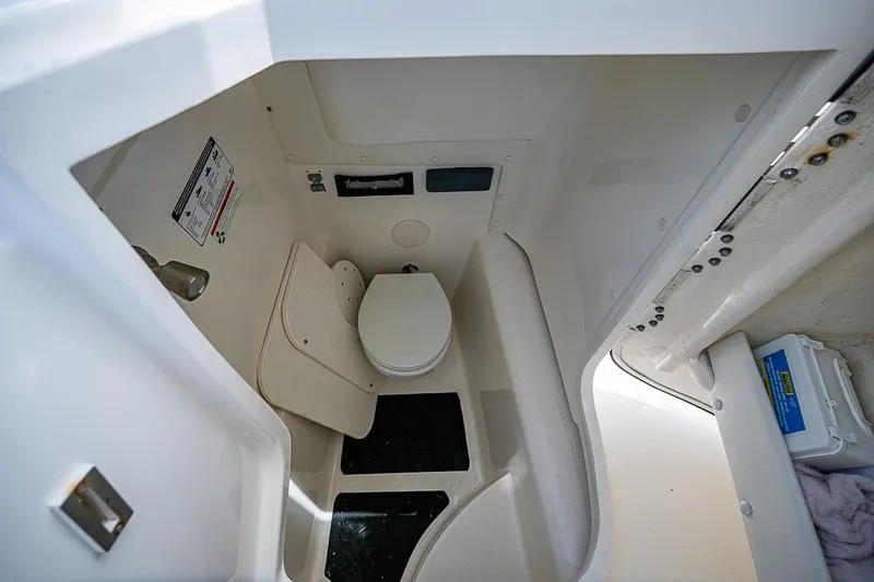 Slide: The Image of Compact marine toilet in a 2020 WorldCat 255 DC boat, featuring white interior and storage space. - 22
