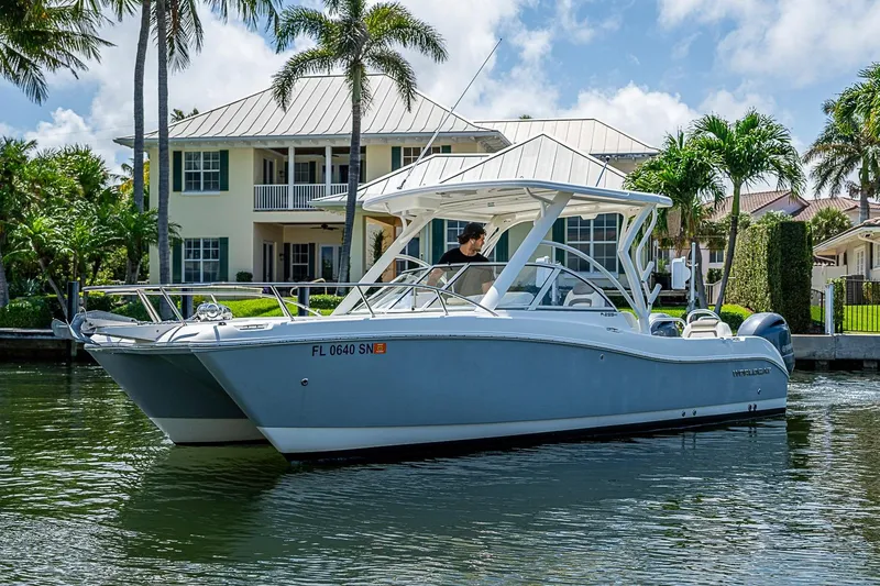 Slide: The Image of 2020 WorldCat 255 DC boat cruising near waterfront homes with palm trees. - 7