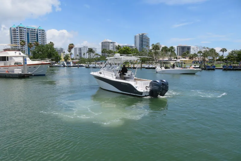 Slide: The Image of 2017 Sea Fox 256 Voyager cruising in a marina with modern buildings in the background. - 3