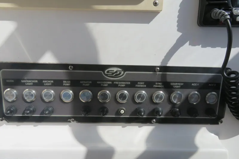Slide: The Image of Control panel of a 2017 Sea Fox 256 Voyager boat with various switches and buttons. - 38