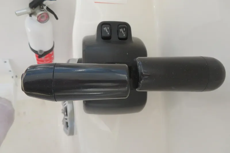 Slide: The Image of Throttle control lever on a 2017 Sea Fox 256 Voyager boat, with a fire extinguisher nearby. - 43