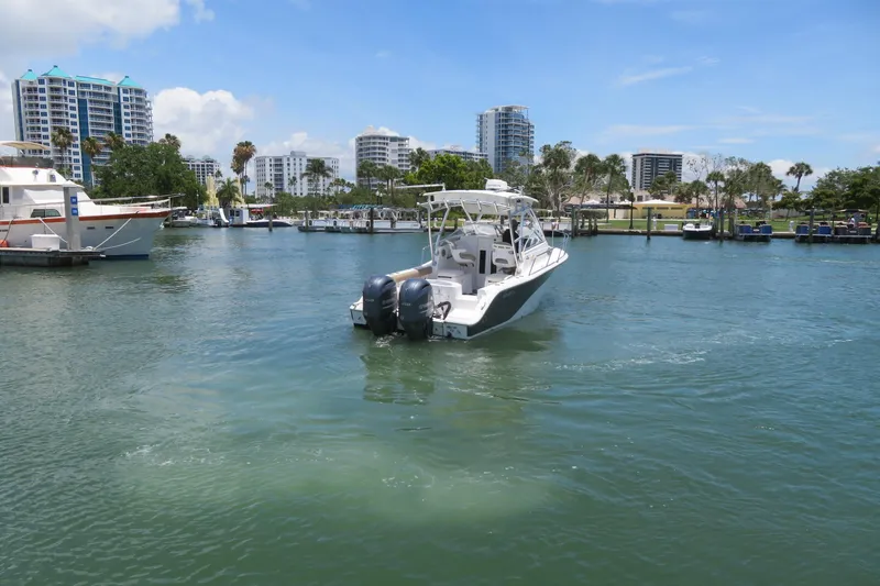 Slide: The Image of 2017 Sea Fox 256 Voyager boat cruising in a marina with city skyline backdrop. - 5