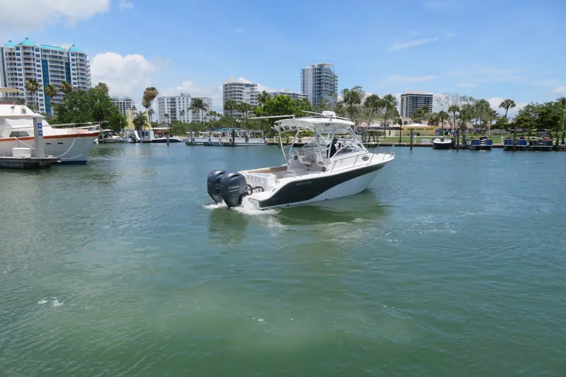 Slide: The Image of 2017 Sea Fox 256 Voyager boat cruising in a marina with cityscape background. - 6