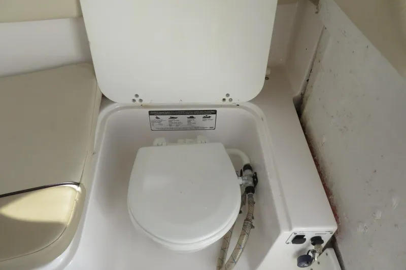 Slide: The Image of 2017 Sea Fox 256 Voyager boat toilet with seat and plumbing connections. - 63