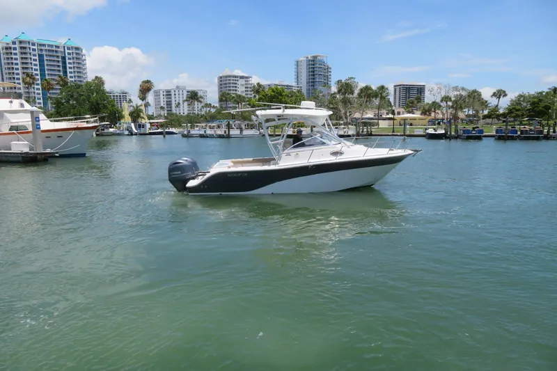 Slide: The Image of 2017 Sea Fox 256 Voyager boat cruising in a marina with cityscape background. - 7
