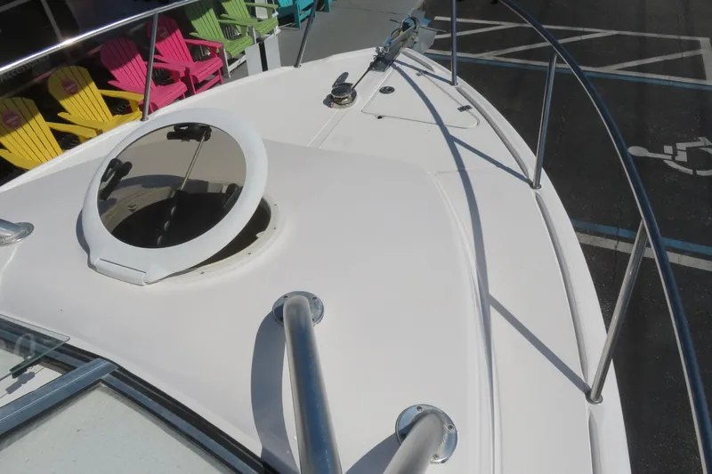 Slide: The Image of 2017 Sea Fox 256 Voyager boat deck with hatch and railing, colorful chairs in background. - 78