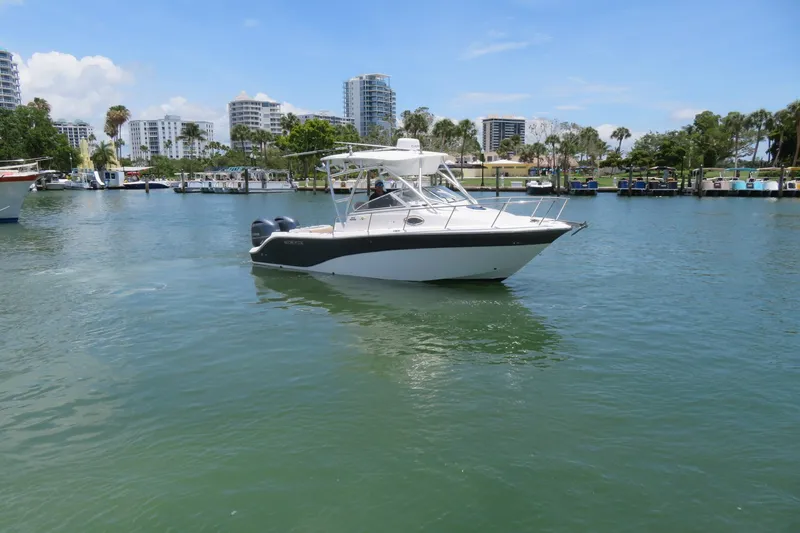 Slide: The Image of 2017 Sea Fox 256 Voyager boat cruising in a scenic marina with city skyline. - 8