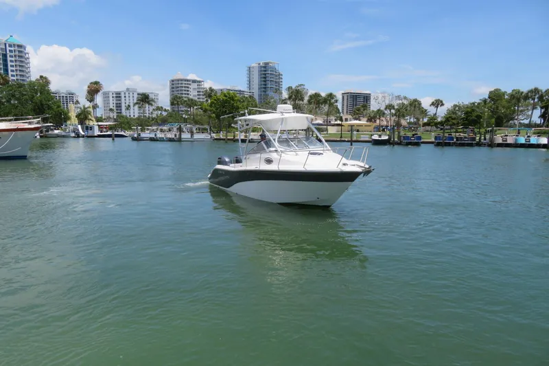 Slide: The Image of 2017 Sea Fox 256 Voyager boat cruising in a scenic marina with modern buildings. - 9