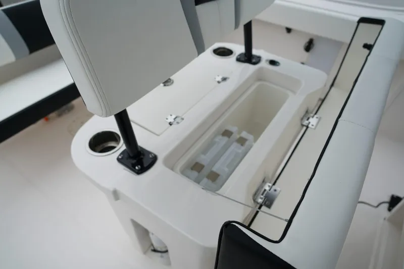 Slide: The Image of 2025 Robalo R222 Center Console boat seating with storage compartment and cup holders. - 10