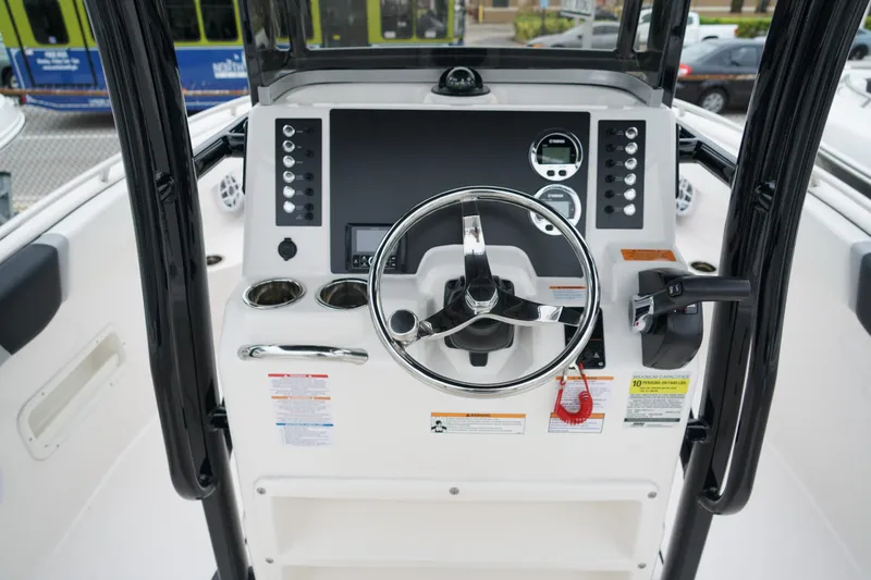 Slide: The Image of 2025 Robalo R222 Center Console boat dashboard with steering wheel and control panel. - 11