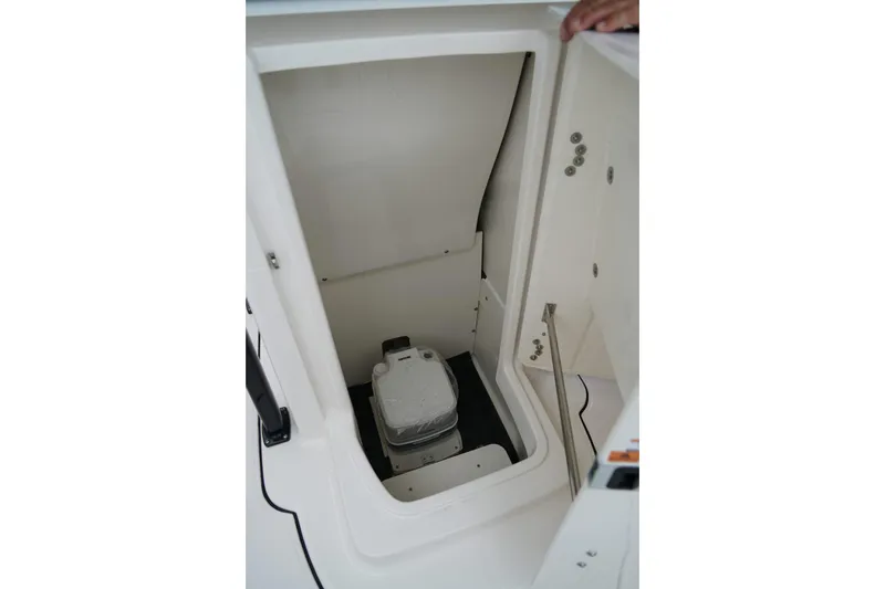 Slide: The Image of 2025 Robalo R222 Center Console boat storage compartment with portable toilet. - 14