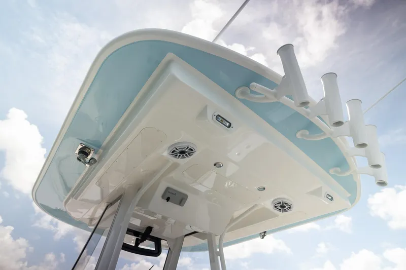 Slide: The Image of 2026 Regulator 31 boat top view with rod holders and speakers against a cloudy sky. - 10