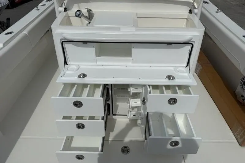 Slide: The Image of 2026 Regulator 31 boat with open storage compartments and sink. - 16