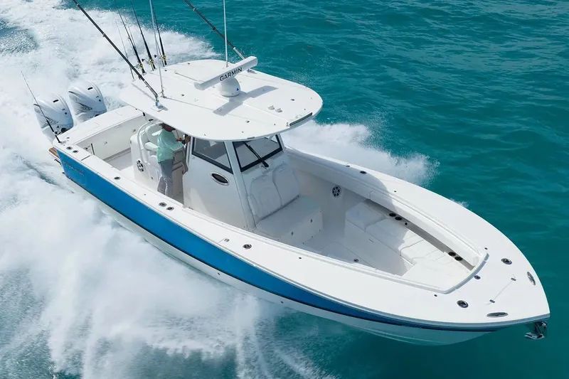 Slide: The Image of Manufacturer Provided Image: 2026 Regulator 31 boat cruising on clear blue water, featuring dual engines and fishing rods. - 30