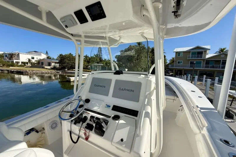 Slide: The Image of 2019 Regulator 31 boat cockpit with Garmin navigation system, docked near waterfront homes. - 15