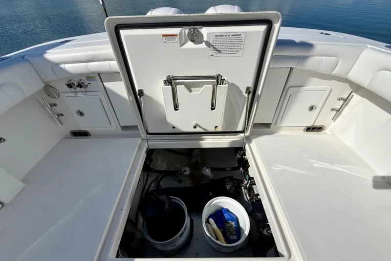 Slide: The Image of Open hatch on 2019 Regulator 31 boat, revealing storage compartment with cleaning supplies. - 18