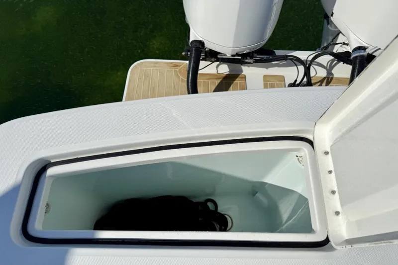 Slide: The Image of Open storage compartment on a 2019 Regulator 31 boat, with visible outboard engines. - 24