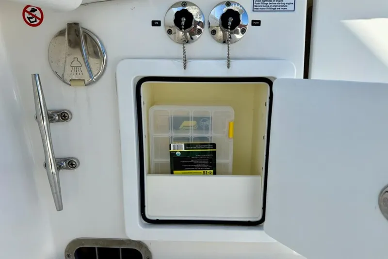 Slide: The Image of Storage compartment on a 2019 Regulator 31 boat, featuring a shower control and tackle box. - 25