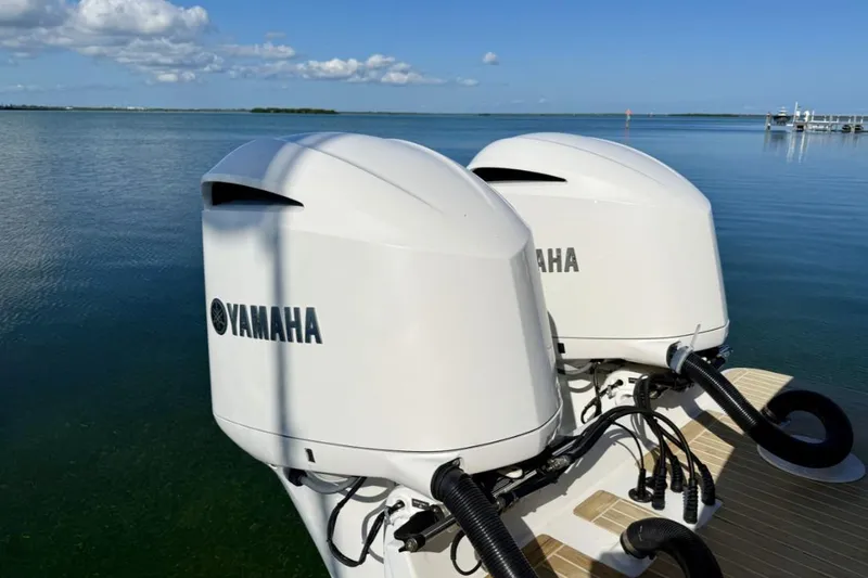 Slide: The Image of Twin Yamaha outboard motors on a 2019 Regulator 31 boat, set against a serene water backdrop. - 27