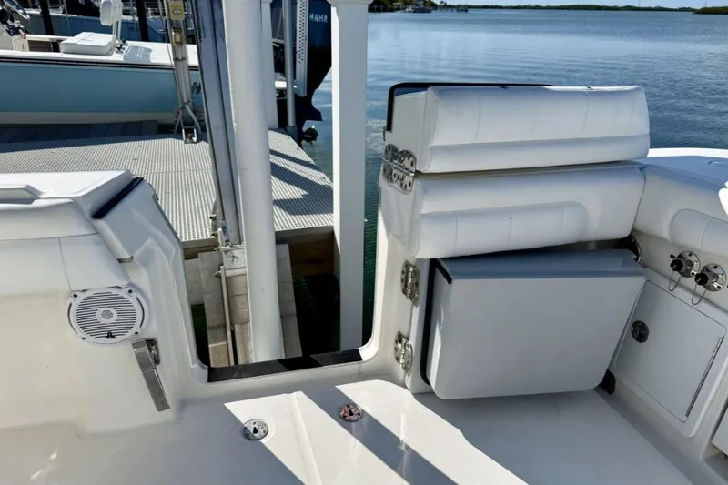 Slide: The Image of 2019 Regulator 31 boat interior with seating and storage, docked by the water. - 28