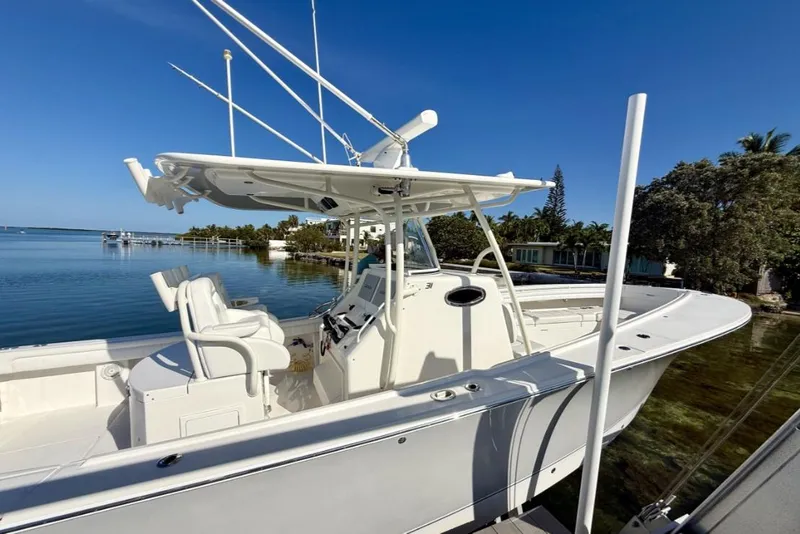 Slide: The Image of 2019 Regulator 31 boat docked by serene waterfront under clear blue sky. - 3