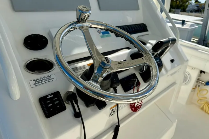 Slide: The Image of Steering wheel and controls of a 2019 Regulator 31 boat cockpit. - 31