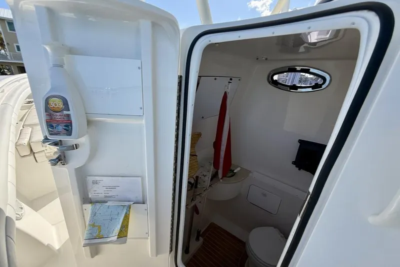 Slide: The Image of Interior view of a 2019 Regulator 31 boat's compact bathroom with cleaning supplies. - 44
