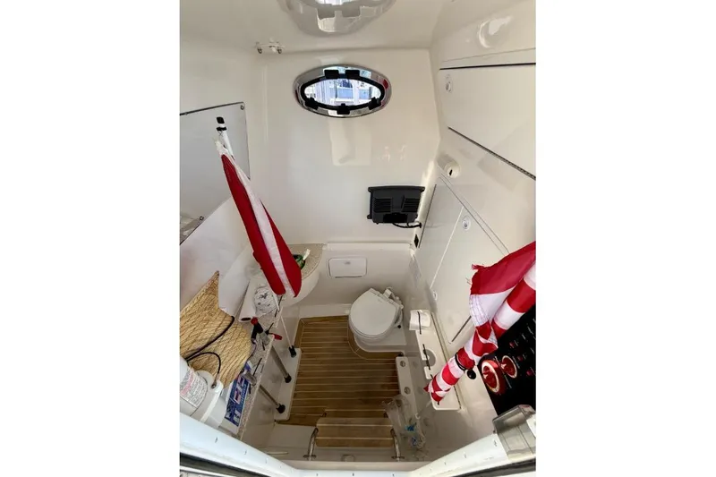 Slide: The Image of 2019 Regulator 31 boat interior with toilet, wooden flooring, and storage compartments. - 45