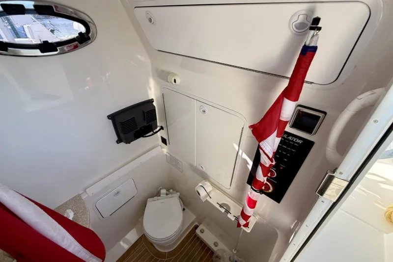 Slide: The Image of 2019 Regulator 31 boat interior with toilet, control panel, and flag. - 46