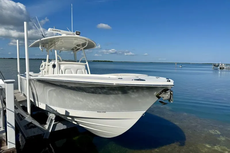 Slide: The Image of 2019 Regulator 31 boat docked by calm waters under a clear blue sky. - 48