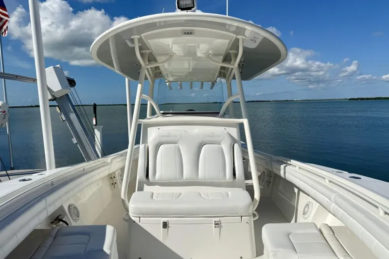 Slide: The Image of 2019 Regulator 31 boat with white seating, docked on calm water under a clear blue sky. - 8