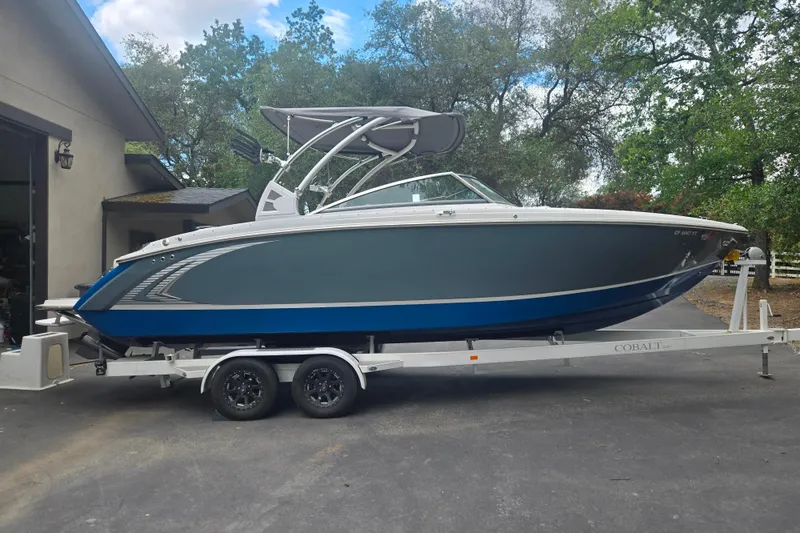 The Image of 2020 Cobalt R7 Surf boat on trailer, parked outdoors near a building. - 1
