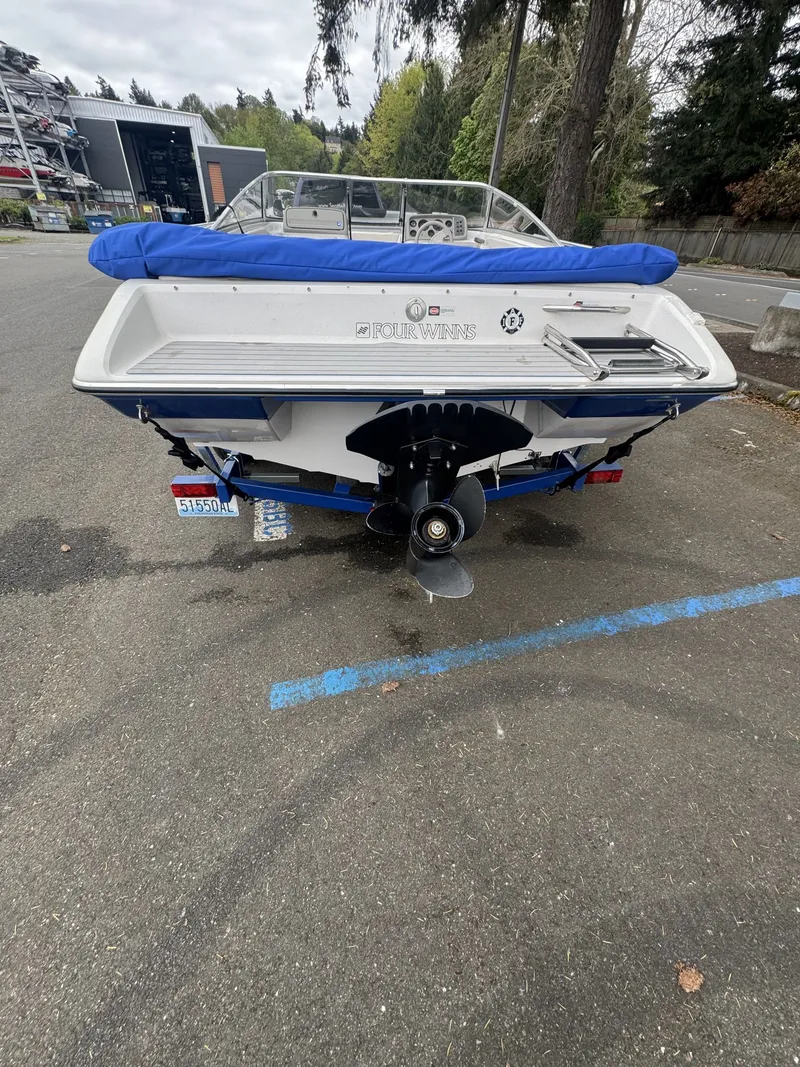 Slide: The Image of Rear view of a 1993 Four Winns 180 Freedom boat in a parking lot. - 7