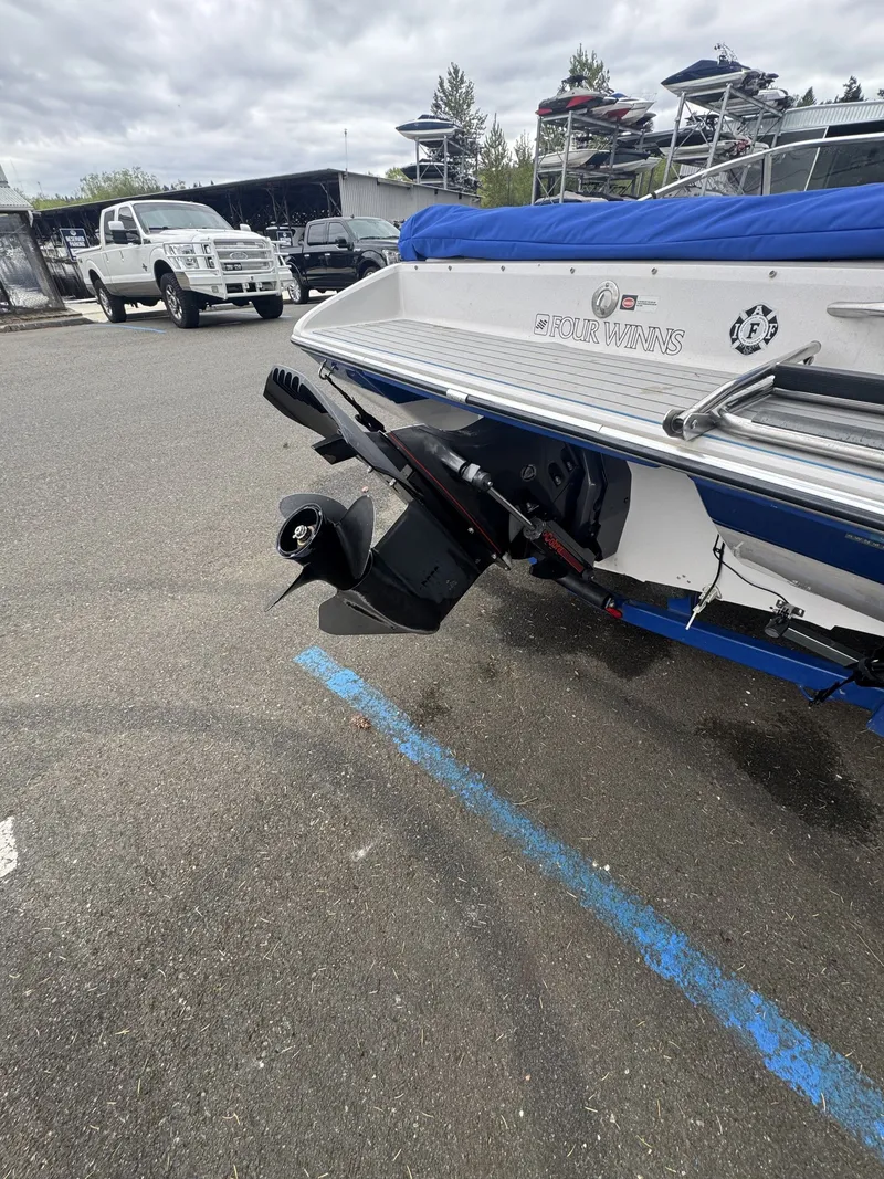 Slide: The Image of Rear view of a 1993 Four Winns 180 Freedom boat in a parking lot. - 8
