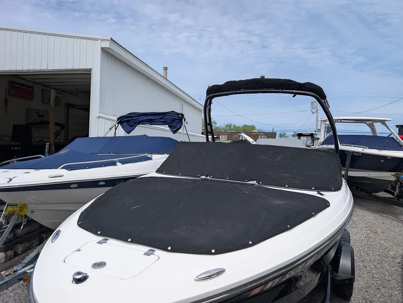 Slide: The Image of 2020 Chaparral SSi 210 boat on trailer outside a garage. - 16