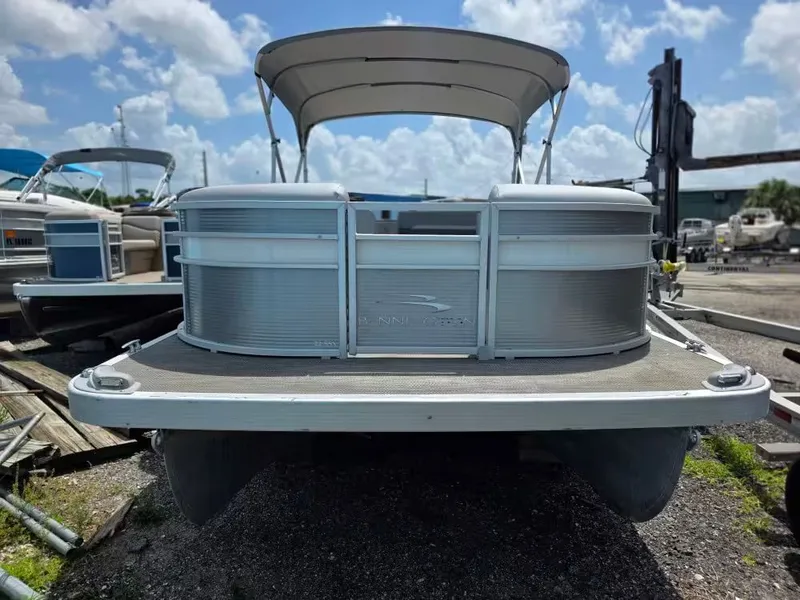 Slide: The Image of 2021 Bennington 22SSX pontoon boat docked under sunny skies. - 2