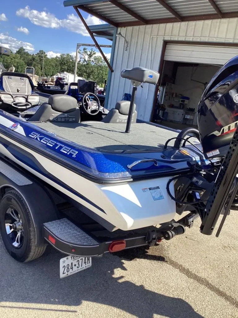 Slide: The Image of 2019 Skeeter ZX225 boat on trailer outside garage. - 15