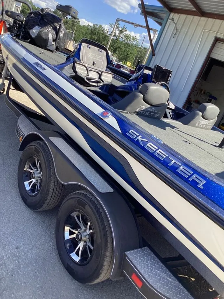 Slide: The Image of 2019 Skeeter ZX225 boat on trailer, blue and white design. - 16