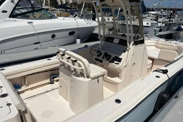 Slide: The Image of 2023 Grady-White Fisherman 236 boat interior at marina, showcasing helm and seating area. - 4