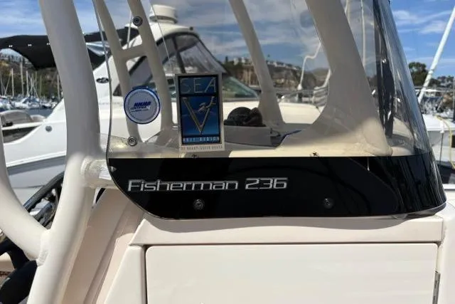 Slide: The Image of 2023 Grady-White Fisherman 236 boat console with logo and marina background. - 6