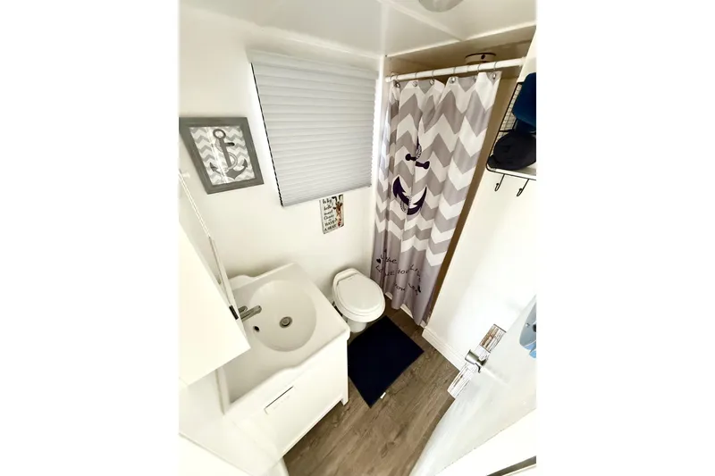 Slide: The Image of Compact bathroom in 1986 Hilburn 4014 Executive, featuring shower, sink, and nautical decor. - 10